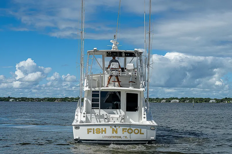  Yacht Photos Pics 1998 Viking 47 Convertible boat named "Fish 'N Fool" on open water.