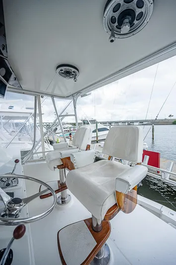  Yacht Photos Pics 1998 Viking 47 Convertible yacht helm with white captain chairs and steering wheel.