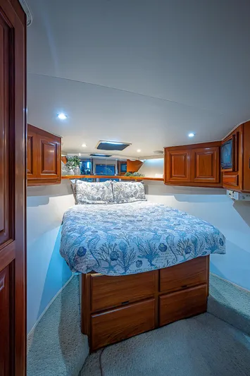  Yacht Photos Pics Cozy bedroom in 1998 Viking 47 Convertible yacht with wooden cabinets and patterned bedding.