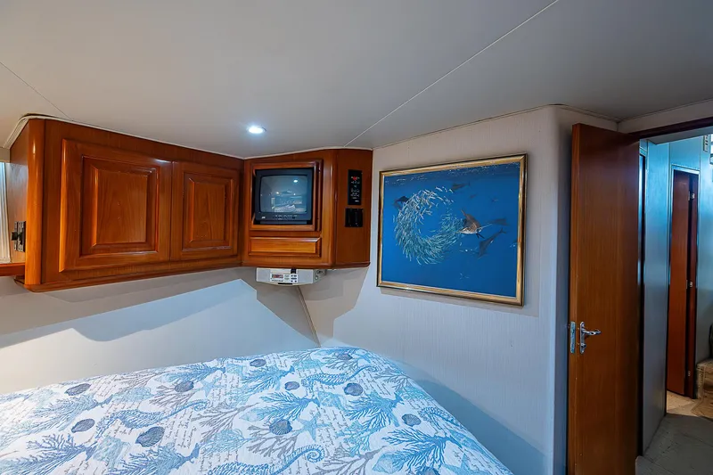  Yacht Photos Pics Cozy bedroom in 1998 Viking 47 Convertible yacht with wood cabinets and marine-themed decor.