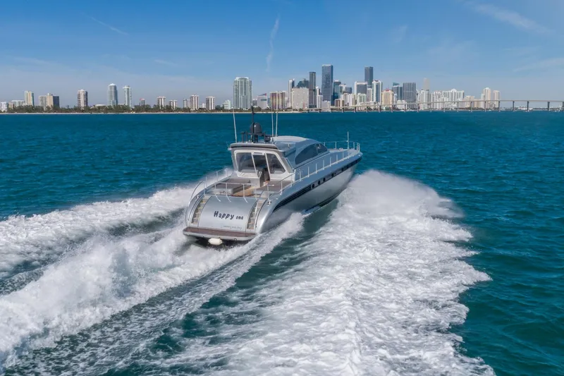Happy One Yacht Photos Pics 2007 Leopard Express Motor Yacht cruising near city skyline on blue ocean waters.