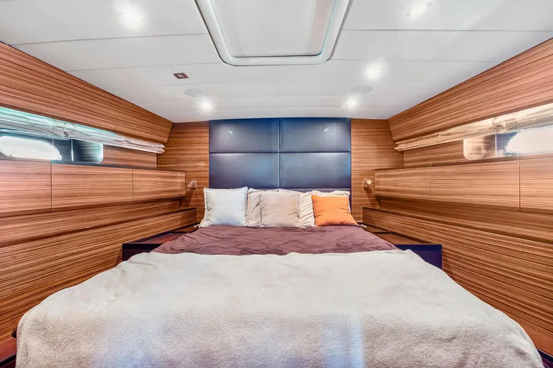 Happy One Yacht Photos Pics Luxurious bedroom interior of 2007 Leopard Express Motor Yacht with wood paneling and cozy bedding.
