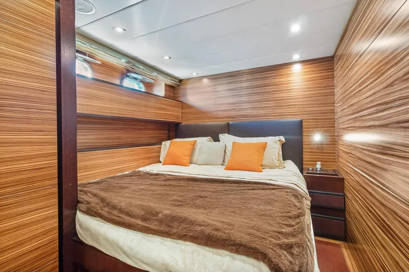 Happy One Yacht Photos Pics Luxurious bedroom interior on 2007 Leopard Express Motor Yacht with wood paneling and cozy bedding.