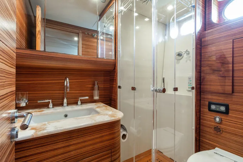 Happy One Yacht Photos Pics Luxurious bathroom in 2007 Leopard Express Motor Yacht with wood paneling and glass shower.