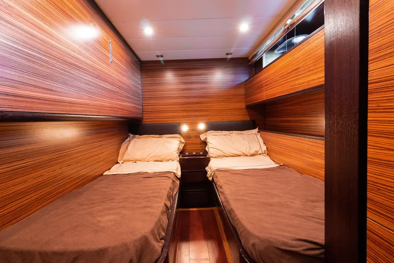 Happy One Yacht Photos Pics Luxurious twin cabin in 2007 Leopard Express Motor Yacht with wood paneling and ambient lighting.
