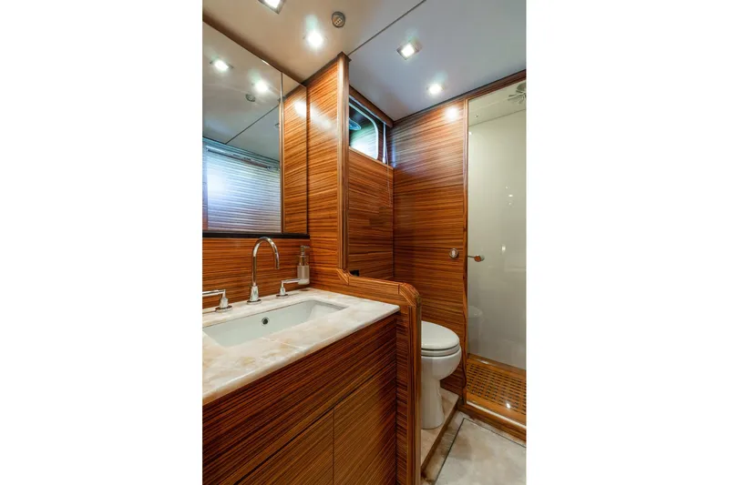 Happy One Yacht Photos Pics Luxurious 2007 Leopard Express Motor Yacht bathroom with wood paneling and modern fixtures.