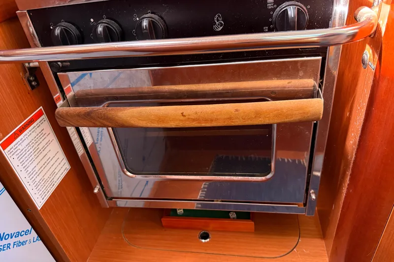 Magic Maddie 2 Yacht Photos Pics Oven in 2010 Beneteau Oceanis 43 yacht kitchen, featuring wooden handle and control knobs.