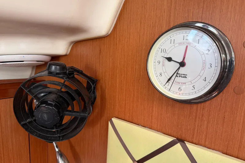Magic Maddie 2 Yacht Photos Pics Interior of 2010 Beneteau Oceanis 43 with tide clock and fan on wooden panel.