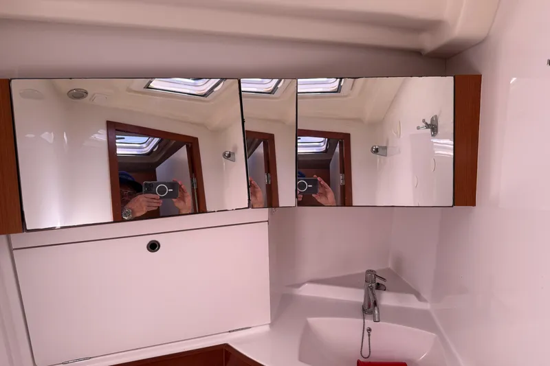 Magic Maddie 2 Yacht Photos Pics Bathroom interior of 2010 Beneteau Oceanis 43 yacht with mirrors and sink.