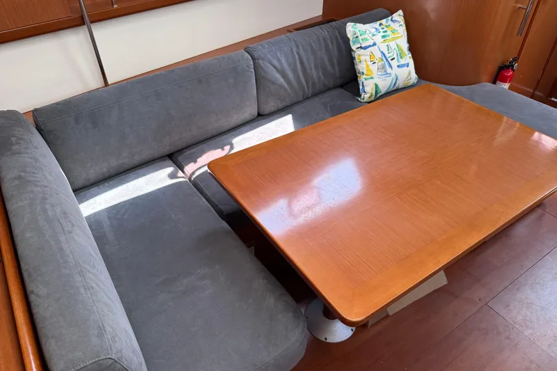 Magic Maddie 2 Yacht Photos Pics Interior of 2010 Beneteau Oceanis 43 yacht with gray seating and wooden table.