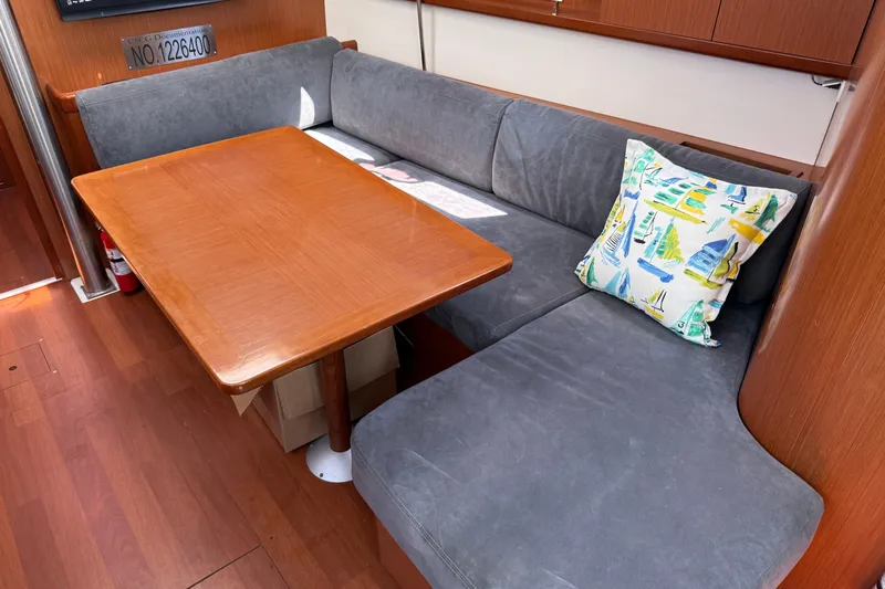 Magic Maddie 2 Yacht Photos Pics Interior of 2010 Beneteau Oceanis 43 yacht with cozy seating and nautical-themed pillow.