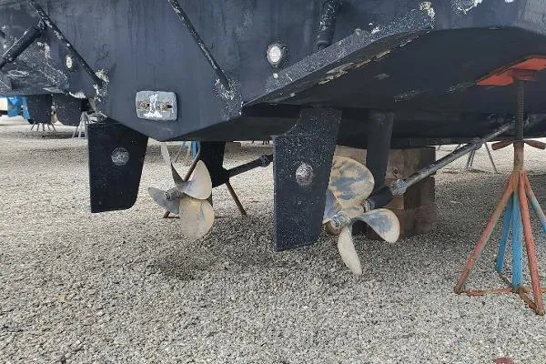 Cash In Advance Yacht Photos Pics 2003 Silverton 38C boat propellers and rudders on gravel, supported by stands.