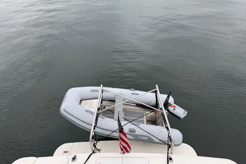 Cash In Advance Yacht Photos Pics 2003 Silverton 38C yacht with inflatable boat and American flag on calm water.