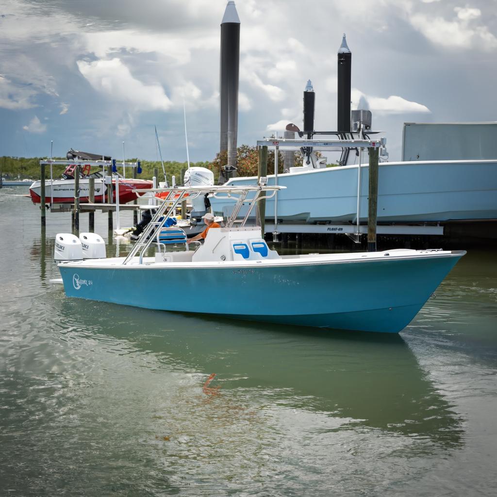 2021 C-Hawk 29CC boat in marina, featuring twin engines and sleek blue design.
