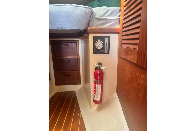 Juniper Yacht Photos Pics Interior of 1988 Pacific Seacraft 34 with fire extinguisher and wooden cabinetry.