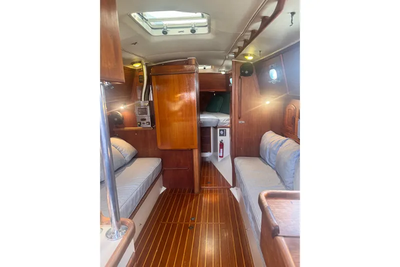 Juniper Yacht Photos Pics Interior of 1988 Pacific Seacraft 34 sailboat with wooden finishes and cozy seating.