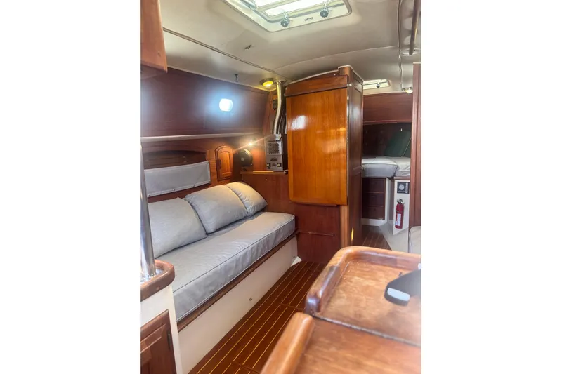 Juniper Yacht Photos Pics 1988 Pacific Seacraft 34 interior with cozy seating and wooden cabinetry.