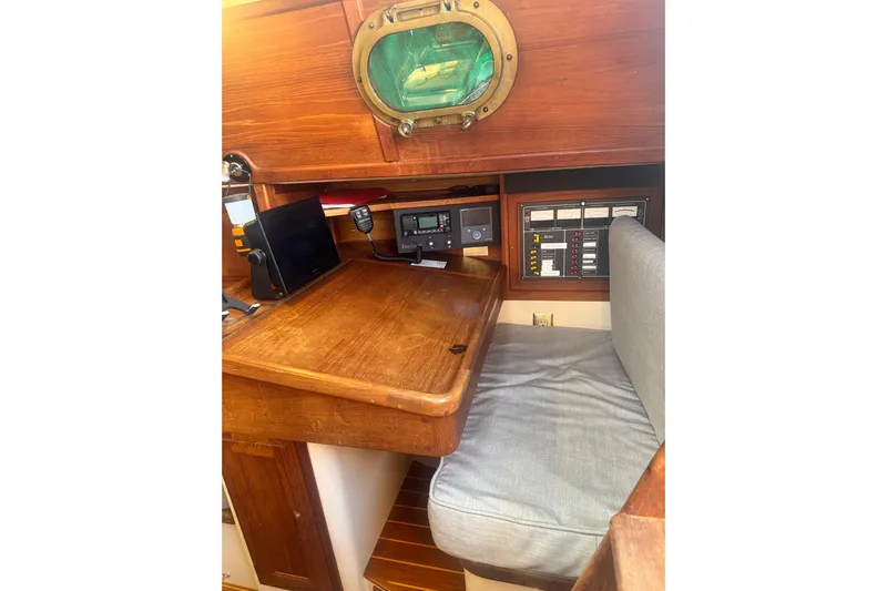 Juniper Yacht Photos Pics Navigation station inside 1988 Pacific Seacraft 34 sailboat with wooden desk and equipment.