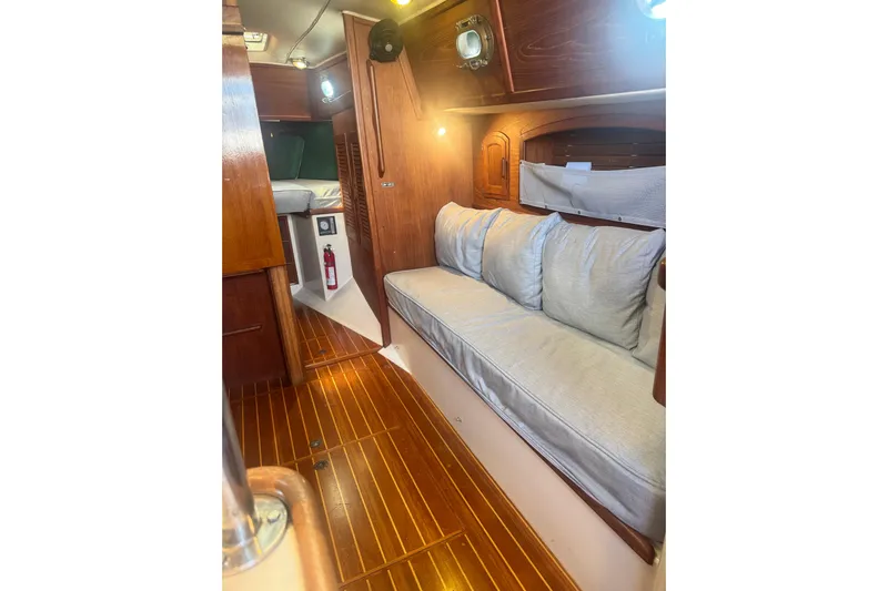 Juniper Yacht Photos Pics Interior of 1988 Pacific Seacraft 34 sailboat with wooden flooring and cozy seating.