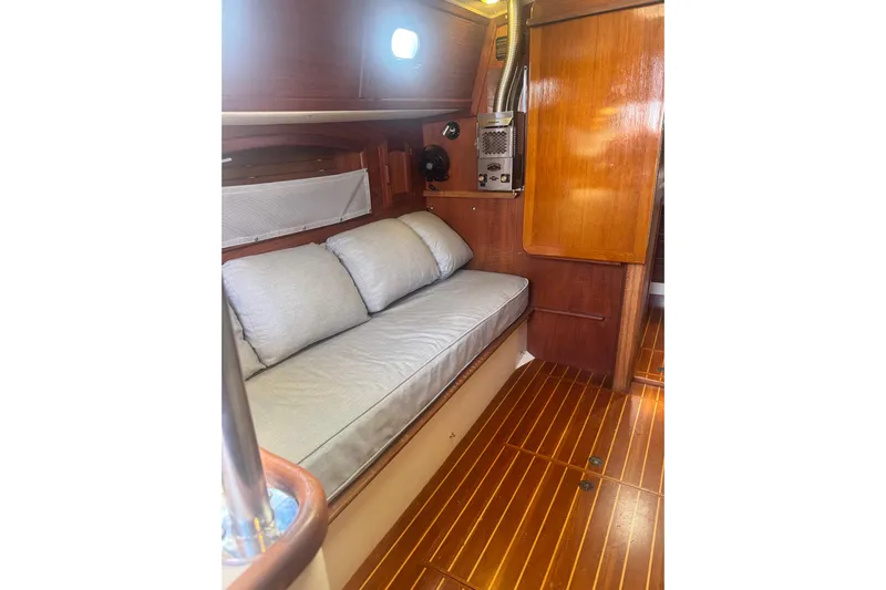 Juniper Yacht Photos Pics Interior of 1988 Pacific Seacraft 34 sailboat with wooden flooring and cushioned seating.
