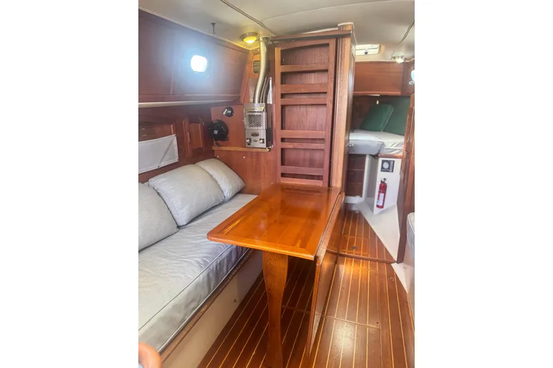 Juniper Yacht Photos Pics Interior of 1988 Pacific Seacraft 34 sailboat with wooden table and cozy seating.