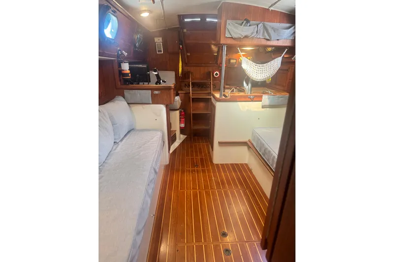 Juniper Yacht Photos Pics Interior of 1988 Pacific Seacraft 34 sailboat with wooden flooring and cozy seating.