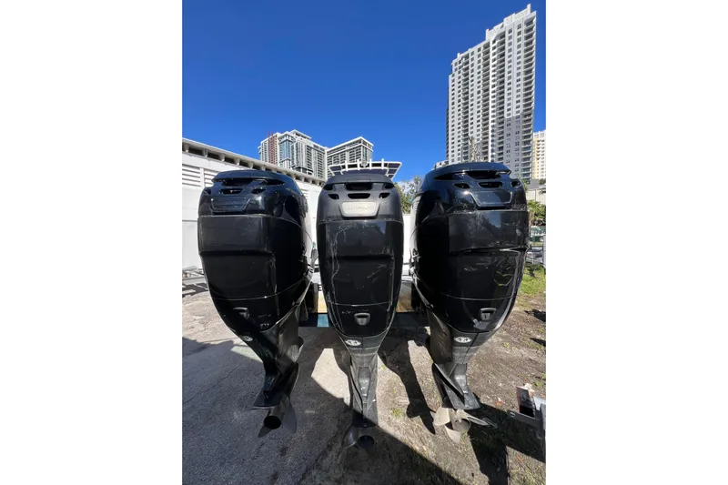  Yacht Photos Pics Three black outboard motors on a 2008 Donzi 38 ZFX Open boat, with cityscape background.