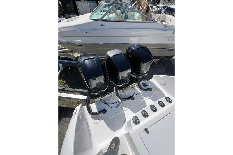  Yacht Photos Pics 2008 Donzi 38 ZFX Open with triple outboard engines, docked beside another boat.