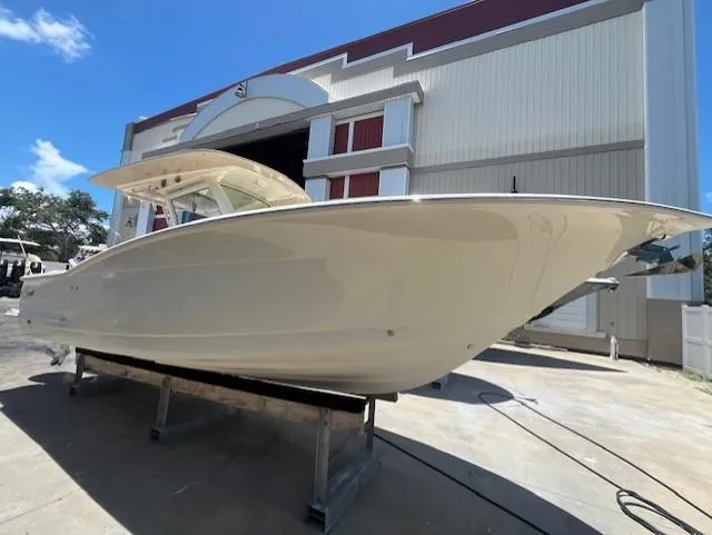  Yacht Photos Pics 2018 Scout 300LXF boat displayed outside a large warehouse.