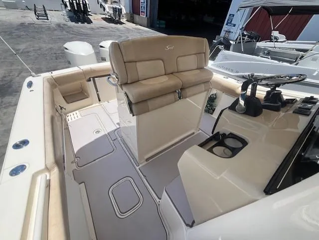  Yacht Photos Pics 2018 Scout 300LXF boat interior with beige seating and control panel.