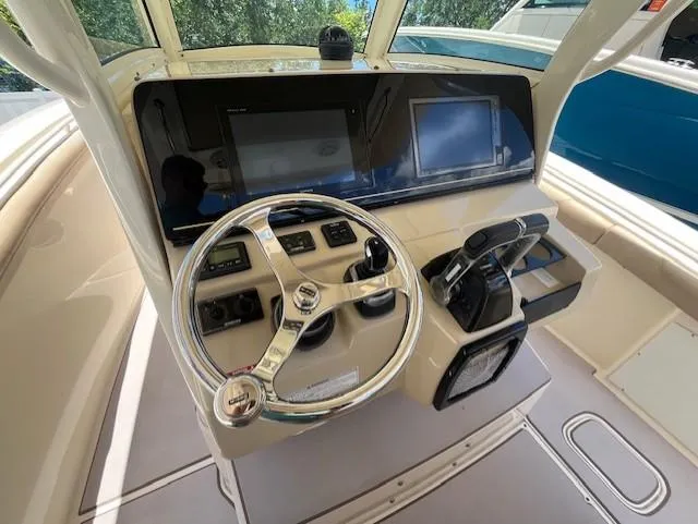  Yacht Photos Pics 2018 Scout 300LXF boat helm with steering wheel and control panel.