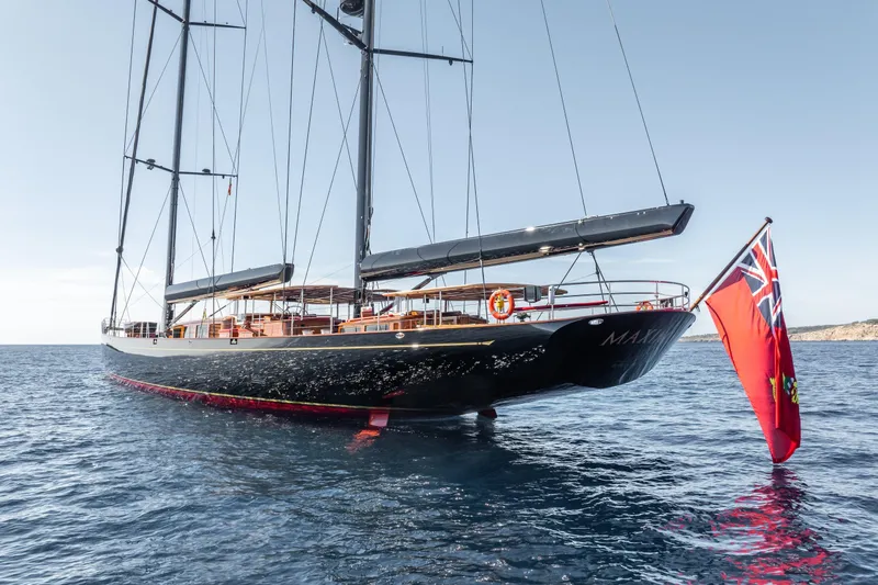 Maximus Yacht Photos Pics 2023 Vitters Cruising Ketch sailing on calm blue waters with a red flag.