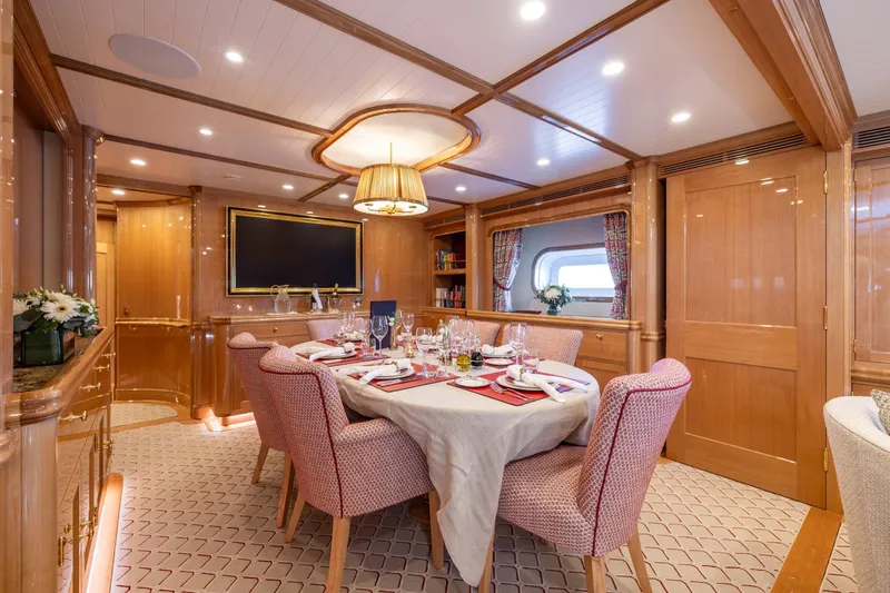 Maximus Yacht Photos Pics Luxurious dining area on 2023 Vitters Cruising Ketch, featuring elegant wood paneling and plush seating.