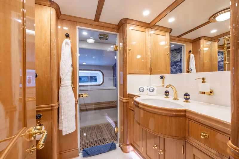 Maximus Yacht Photos Pics Luxurious 2023 Vitters Cruising Ketch bathroom with elegant wood cabinetry and gold fixtures.