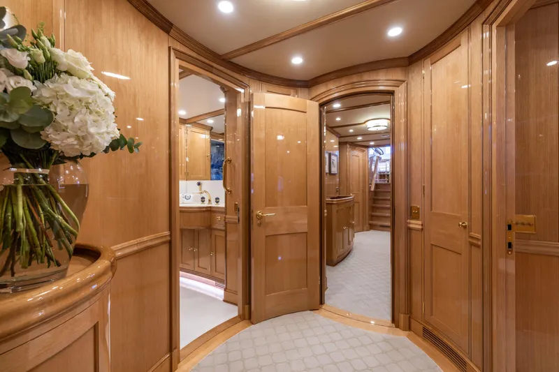 Maximus Yacht Photos Pics Luxurious interior of 2023 Vitters Cruising Ketch with elegant wood paneling and floral arrangement.