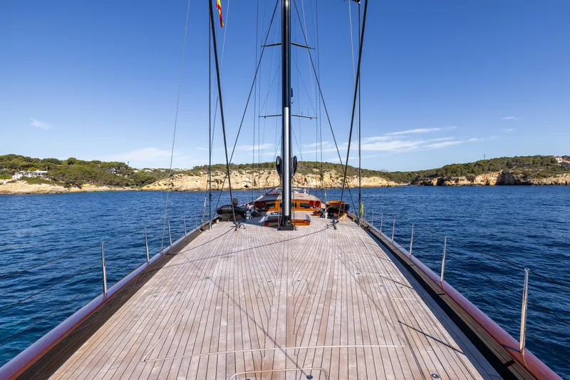 Maximus Yacht Photos Pics 2023 Vitters Cruising Ketch sailing on calm blue waters, clear sky, scenic coastline.