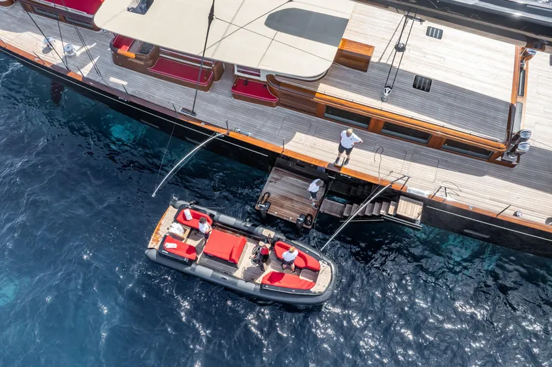 Maximus Yacht Photos Pics 2023 Vitters Cruising Ketch with tender boat, docked in clear blue water.
