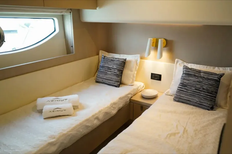  Yacht Photos Pics Luxurious twin cabin in 2024 Azimut Fly 68 yacht, featuring elegant bedding and modern design.