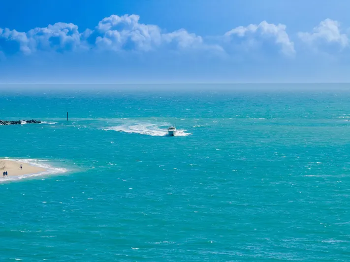  Yacht Photos Pics 2007 Grady-White Express 360 boat cruising on turquoise ocean near sandy beach.