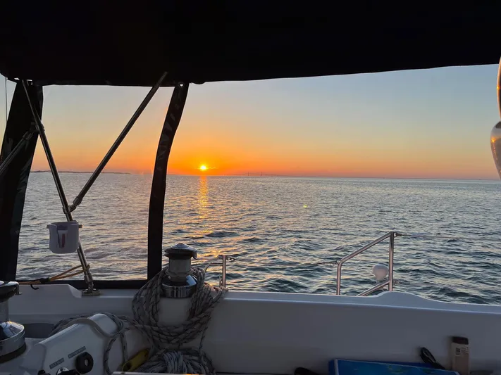  Yacht Photos Pics Sailing on a 2005 Hunter 456 yacht at sunset over calm ocean waters.