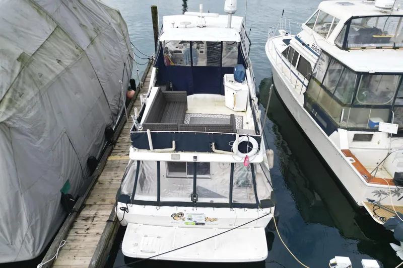Cuatro Yacht Photos Pics 1998 Bayliner 4788 Pilot House Motoryacht docked between boats.