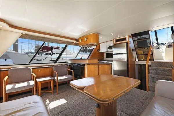 Cuatro Yacht Photos Pics Interior of 1998 Bayliner 4788 Pilot House Motoryacht with seating, table, and kitchen area.