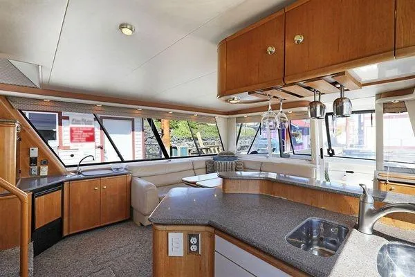 Cuatro Yacht Photos Pics Luxurious interior of 1998 Bayliner 4788 Pilot House Motoryacht with modern kitchen and seating area.