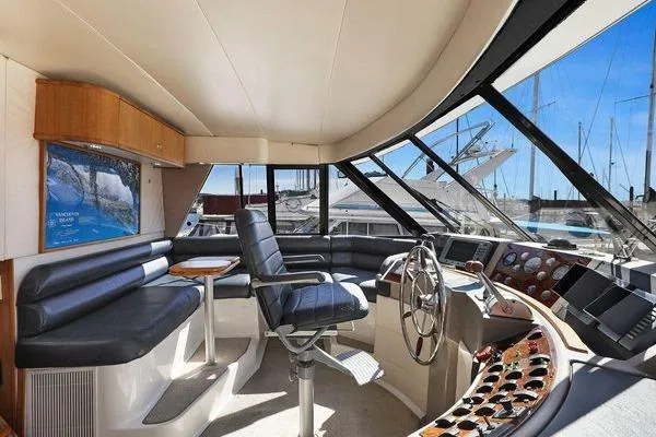 Cuatro Yacht Photos Pics 1998 Bayliner 4788 Pilot House Motoryacht interior with helm, seating, and panoramic windows.