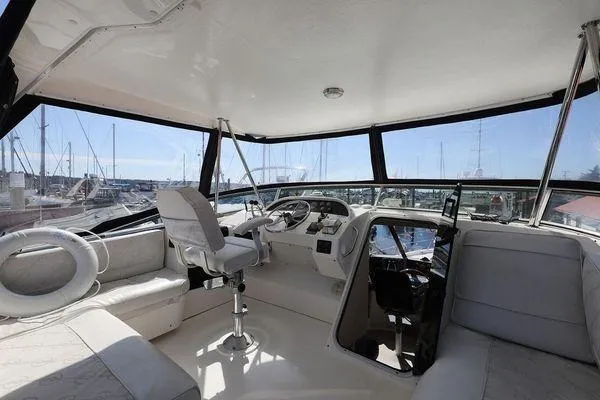 Cuatro Yacht Photos Pics 1998 Bayliner 4788 Pilot House Motoryacht interior with helm, seating, and marina view.