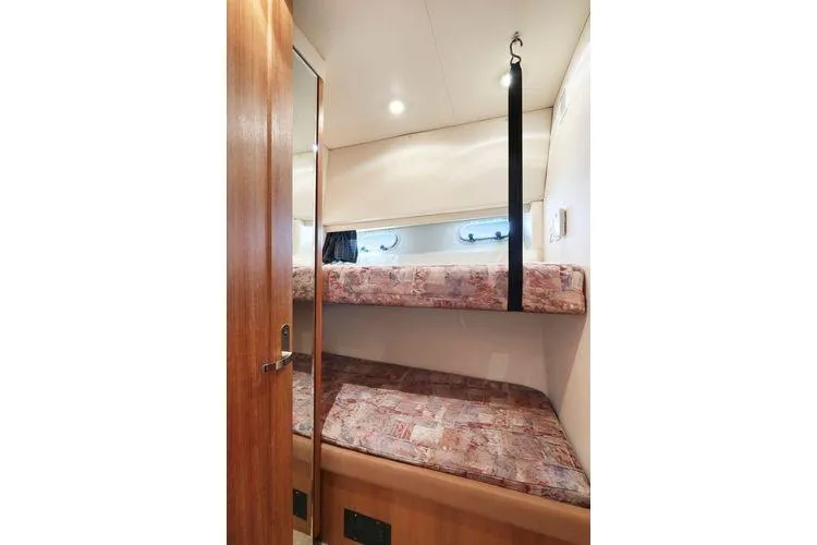 Cuatro Yacht Photos Pics 1998 Bayliner 4788 Pilot House Motoryacht cabin with bunk beds and wooden interior.