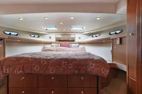 Cuatro Yacht Photos Pics Luxurious bedroom interior of 1998 Bayliner 4788 Pilot House Motoryacht with skylights and wood cabinetry.