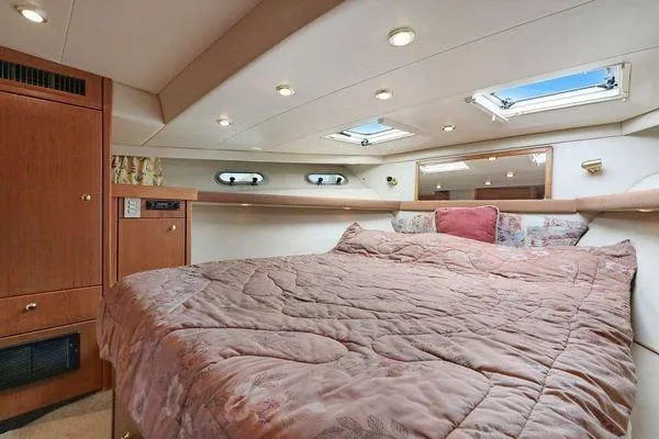Cuatro Yacht Photos Pics Luxurious bedroom interior of 1998 Bayliner 4788 Pilot House Motoryacht with skylights and cozy bedding.