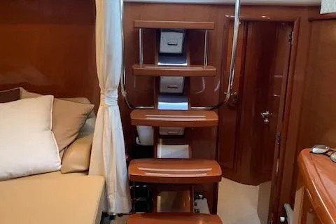  Yacht Photos Pics Interior of 2009 Jeanneau Prestige 50 HT yacht with wooden stairs and cozy seating area.