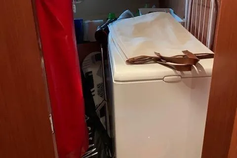  Yacht Photos Pics Interior storage area on a 2009 Jeanneau Prestige 50 HT yacht, cluttered with various items.